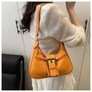 Detail of bright orange crescent bag with silver metallic buckles and vintage zippers