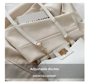 Gros plan sur la texture du cuir blanc et la boucle dorée réglable de la bandoulière