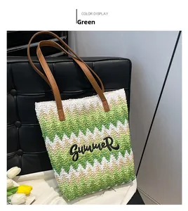 Detail of summer straw tote bag with green wave patterns and 'SUMMER' embroidery