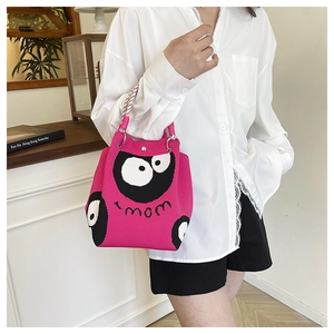 Detail of rose pink knit tote bag with cartoon eye design and colorful braided handle