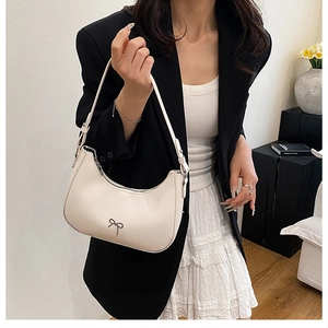 Chic cream bow shoulder bag styled with a blazer and lace dress for a vintage look
