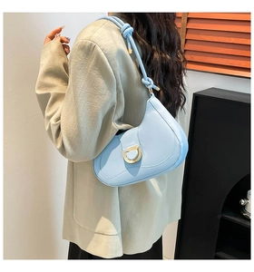 Detail of light blue hobo bag with gold horsebit buckle and knotted shoulder strap
