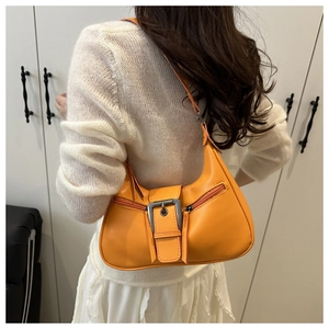 Detail of bright orange PU leather crescent bag with silver buckles and double zippers