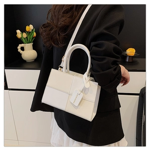 Close-up of stylish white crossbody bag on a model in a modern interior setting