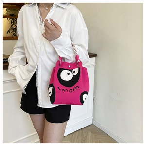 Détail de la maille d'un sac seau rose à motif cartoon et bandoulière arc-en-ciel