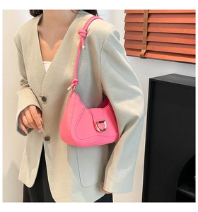 Close-up of pink PU leather underarm bag with gold D-buckle and knotted strap detail