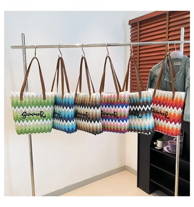 Close-up of woven straw tote bags with Summer embroidery and stylish leather handles