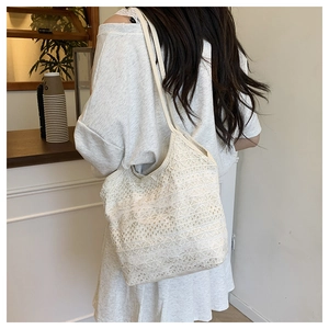 Détail du sac cabas en dentelle avec motif floral géométrique ajouré beige crème