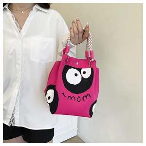 Detail of rose pink knit tote bag featuring cartoon eyes, mom text and braided handles