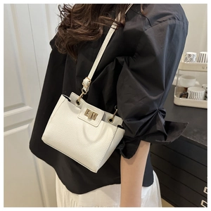 Détail d'un sac à main blanc en cuir grainé avec fermoir rotatif en métal doré chic