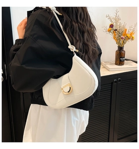 Close-up of white minimalist crescent saddle bag with gold D-buckle detail on model