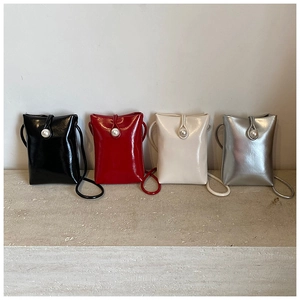 Detail of four patent leather bucket bags with pearl buckles in black red cream and silver
