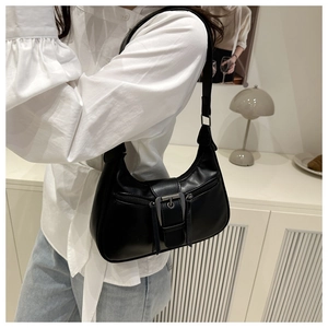 Detail view of a black retro hobo bag with silver buckles shown on a model