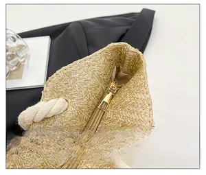 Detailed view of the smooth metal zipper and woven texture on a beige straw tote bag