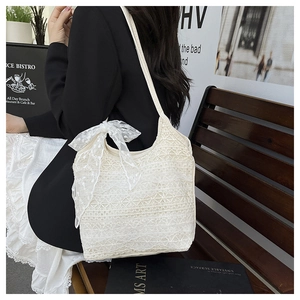 Détail du sac cabas en dentelle florale blanche avec un grand nœud décoratif
