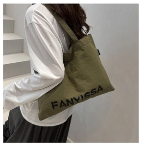 Side view of an army green nylon tote bag with black FANYVISSA lettering on a model