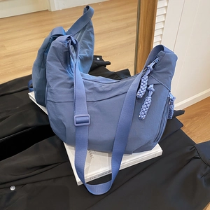 Sac bandoulière en nylon bleu en forme de croissant avec tirettes tissées en vue miroir