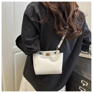 Sac bandoulière blanc motif litchi avec fermoir doré porté à l'épaule par un mannequin