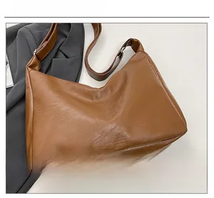 Detail view of the soft brown leather texture and silver buckle on the hobo tote bag