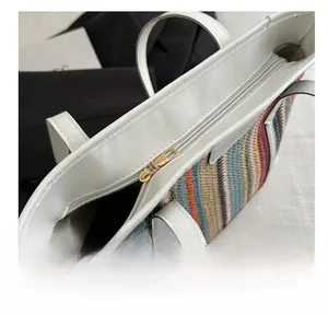 Gros plan sur le sac fourre-tout à rayures avec bordure en cuir blanc et fermeture éclair