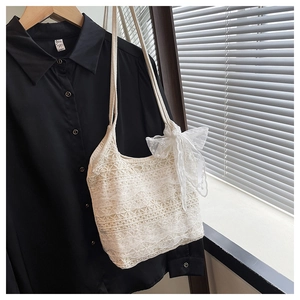 Détail du sac cabas en dentelle blanche avec broderie florale et grand nœud en tulle
