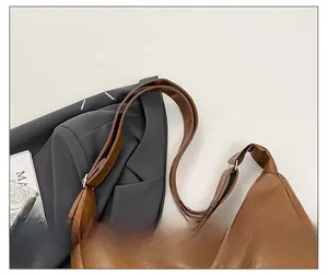 Detail of adjustable wide shoulder strap on brown pebble leather tote bag