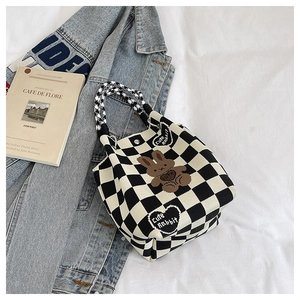 Close-up of knit checkerboard tote bag with cute rabbit pattern and soft texture