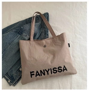 Close-up of FANYISSA large canvas tote bag with magnetic snap button closure and logo detail