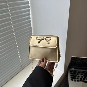 Mini gold chain saddle bag with metallic finish and decorative bow clasp for women