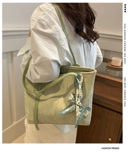 Detail of light green tote bag with pleated texture and decorative silk scarf