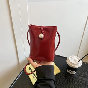 Red leather mini crossbody phone bag with large pearl closure and elegant shoulder strap