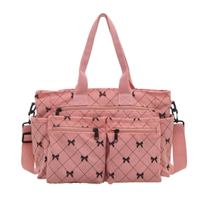 Pink corduroy tote bag with quilted diamond pattern and black bow accents for women