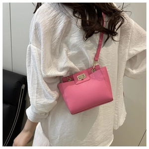 Détail du sac bandoulière rose motif litchi avec fermoir tournant métallique doré chic