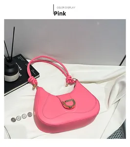 Pink crescent underarm bag featuring gold D-buckle detail and knotted straps