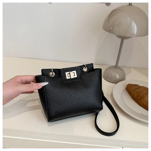 Détail du sac à main en cuir noir grainé avec fermoir rotatif en métal doré élégant