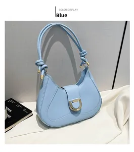 Detail of light blue crescent bag with golden D-buckle and elegant knotted shoulder strap