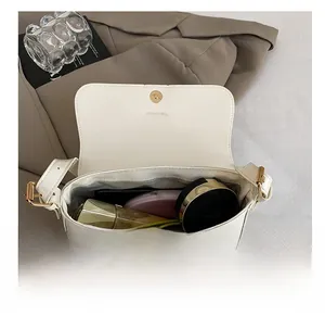 Interior view of white leather crossbody bag showing capacity for phone and cosmetics