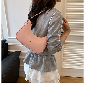 Close-up of pink hobo bag featuring a silver bow detail and adjustable shoulder strap