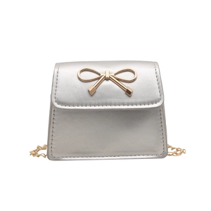 Silver mini crossbody bag with gold bow clasp and metal chain strap on white background