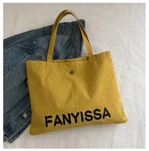 Detail of ginger canvas tote bag featuring magnetic closure and FANYISSA printed logo