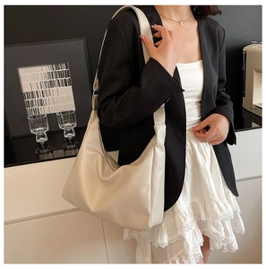Detail of off-white lychee grain faux leather hobo tote bag with wide shoulder strap