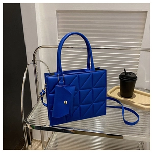 Elegant cobalt blue quilted handbag for women, featuring a matching mini pouch charm.