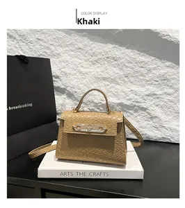 Detail of khaki textured handbag with gold twist lock and adjustable shoulder strap