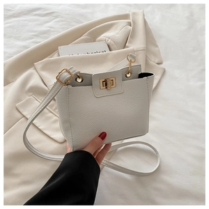 Détail du sac blanc en cuir à grain de litchi avec fermoir tournant doré élégant