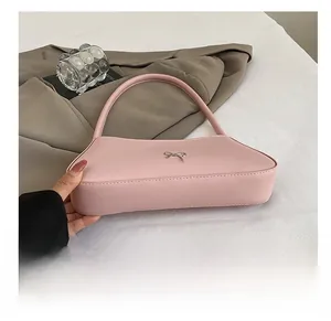 Detailansicht einer rosa rechteckigen Handtasche mit einer schicken Metallschleife vorne