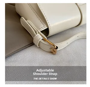 Detail of adjustable white faux leather strap with golden metal buckle and fine stitching