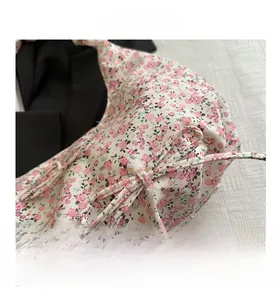 Gros plan sur le motif floral rose et le cordon de serrage du sac en tissu doux