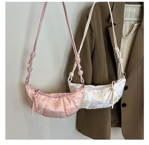 Detail of embroidered butterfly on jacquard satin crescent bag with knotted shoulder strap