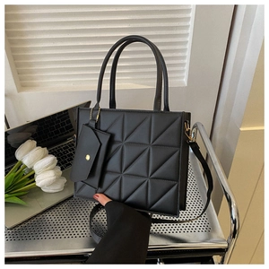 Detail view showing a black quilted handbag with geometric pattern and small pouch