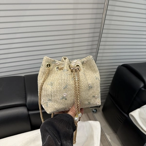Beige woven straw bucket bag with floral embroidery and pearl chain strap